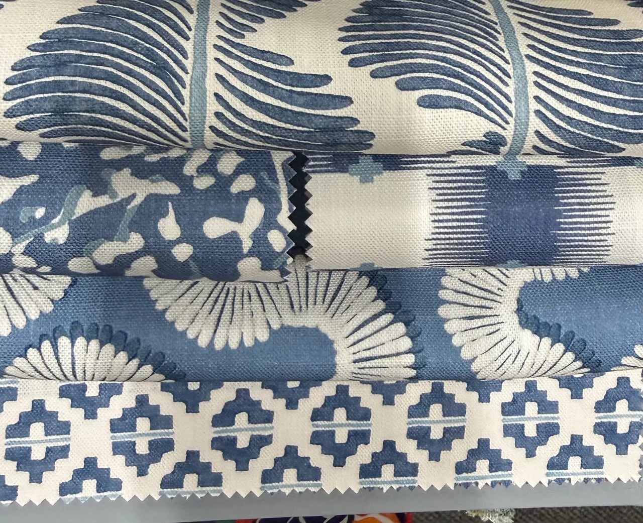 Folded blue and white printed fabric samples stacked in layers